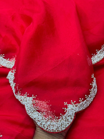 Organza saree featuring delicate scalloped pearl beadwork border with matching unstitched heavy blouse embellished in intricate pearl detailing – ideal for festive and wedding wear.