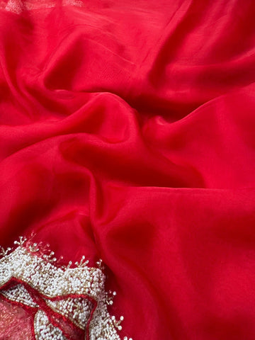 Organza saree featuring delicate scalloped pearl beadwork border with matching unstitched heavy blouse embellished in intricate pearl detailing – ideal for festive and wedding wear.