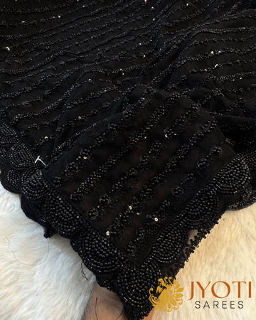 Black net saree with full bead and sequin embroidery and heavy scalloped border