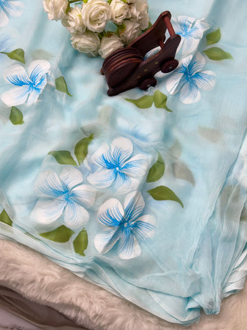Hand-painted chiffon saree with large floral motifs in pastel shades – lightweight, flowy, and elegant.

