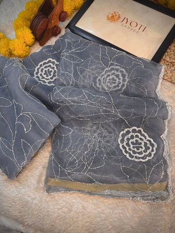 Glass tissue saree with floral embroidery in cutdana and pearl work, scalloped border, and unstitched blouse piece – by Jyoti Sarees