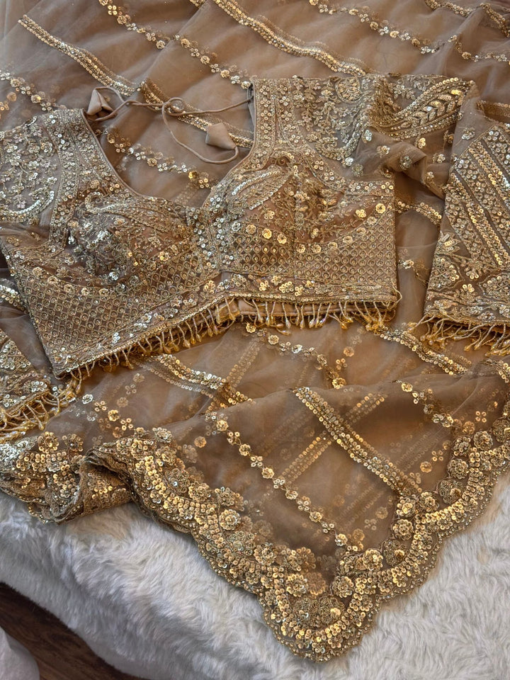 Golden net saree with stitched heavy blouse featuring sequin and floral embroidery, champagne gold tone