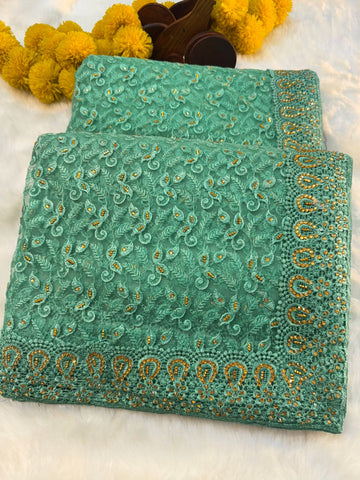 "Elegant net saree with intricate jaal embroidery and embellished border, paired with matching unstitched blouse – perfect for festive and wedding wear