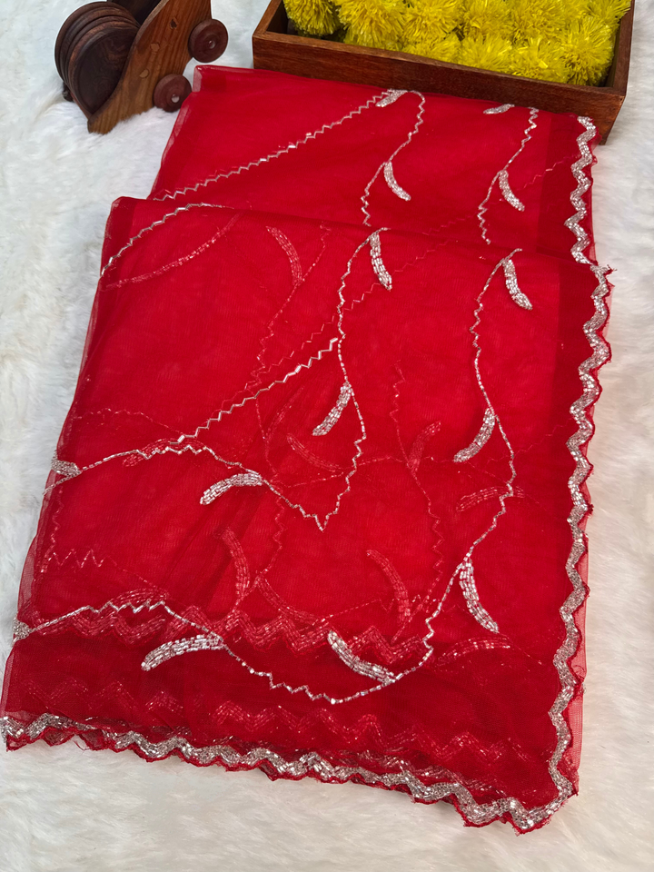 Designer net saree with abstract scalloped sequin embroidery, available in red, yellow, and sky blue – with matching blouse from Jyoti Sarees